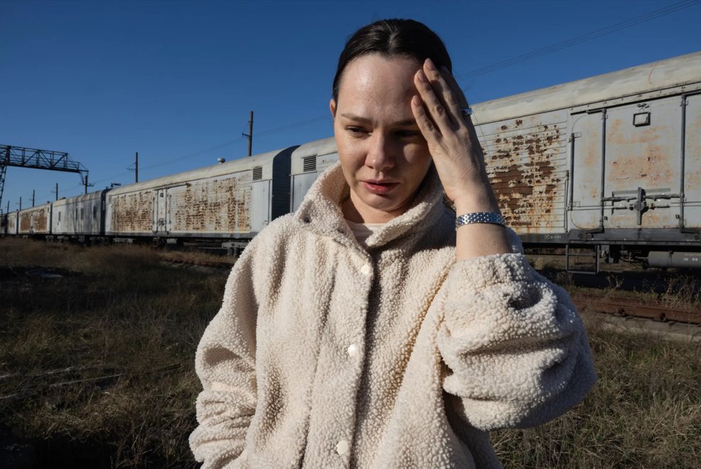 Kateryna Androsova in front of railway wagons